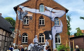 Macht die Dimensionen klar: Die Teilnehmer der Führung marschieren an den großen Paste-Ups entlang. - Tschackert/Osterkamp Macht die Dimensionen klar: Die Teilnehmer der Führung marschieren an den großen Paste-Ups entlang. - Tschackert/Osterkamp