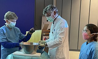Zwei Studenten der Kinderuni werden in den Assistentenstand erhoben und helfen dem Mediziner Jost Niedermeyer dabei, zu zeigen, wie Fische über ihre Kiemen atmen. - Elke Niedringhaus-Haasper