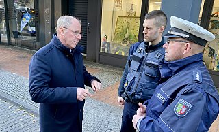 In der Paderborner Marienstraße informiert sich Bürgermeister Stefan-Oliver Strate (l.) bei Polizeihauptkommissar Hubertus Kuhaupt (r.) und Ordnungsamtsmitarbeiter Niclas Vogt über die Lage vor Ort. - Stadt Paderborn