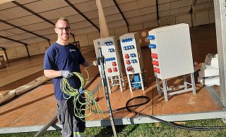 Kai Jonietz, Elektriker bei den Stadtwerken, bringt einen der Erdungspins am Gewerbezelt an. Weit bevor die ersten Aussteller für ihre Stände Strom brauchen. „Das Kabel erdet die Verteiler im Zelt“, sagt er. - Dieter Scholz