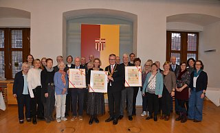 Bürgermeister Michael Dreier (Mitte) überreicht den Heimat-Preis an Heimatkünstler Egon Hüls (v.l. mit Urkunde), Linda Dülme (Leiterin der Bücherei Marienloh) und Steffen Laux (Vorsitzender des Städtischen Musikvereins Paderborn). - Stadt Paderborn/Miriam Brune