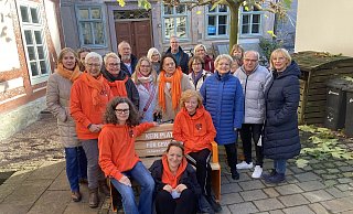 Vizepräsidentin Annette Finkeldei und Präsidentin Leonore von Falkenhausen (vorn) freuen sich mit weiteren engagierten Frauen und Männern, die orangefarbene Bank ans Forum Anja Niedringhaus und das Museum im Jacob-Pins-Forum zu übergeben. - Zonta