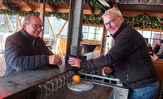Stammkunde Markus Kamp (l.) wird auf dem Gütersloher Weihnachtsmarkt schon seit Jahren von "Hölzi" bedient. - Dana Thoeren