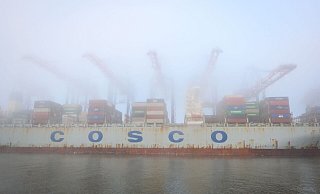 Das Containerschiff «Cosco Pride» liegt im dichten Nebel am Containerterminal Tollerort im Hamburger Hafen. - Jonas Walzberg/dpa