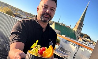 Atakan Sandal präsentiert auf der Dachterrasse einen Frucht-Bowl. Die Freiluftfläche ist bei den Gästen beliebt und bei Sonnenschein stets gut bevölkert. - Eike J. Horstmann