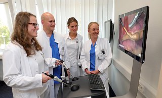 Spaß beim Training: Luise Lüth, Reinhold Steinbach, Shioban Maatz und Viola Frehe demonstrieren eine virtuelle Operation am Darm. Das Foto aus dem Bauchraum ist hier in den Bildschirm einmontiert. - Frank-Michael Kiel-Steinkamp