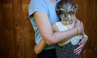 Ein Mädchen wird von seiner Mutter in den Arm genommen und getröstet. (gestellte Szene) - picture alliance/dpa