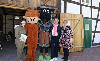 Zur Emsel-Erlebnis-Aktion in der Kulturscheune laden die Autorin und Zeichnerin Joana Mertens (v.l.), der flauschige Emsel „Pellework“, das Maskottchen Hövel-Schnucki, die Geschäftsführerin des Verkehrsvereins Angelika Schäfer und Meike Lippegaus von der Geschäftsstelle Ems Radweg ein. - Regina Brucksch