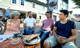 Familientreffen bei Kaffee und Kuchen: Nesrin Sayar (l.) vor ihrem Café am Dreiecksplatz im Gespräch mit ihren "Söhnen" (v.l.) Amir Reza Gholamhossein, Saman Shirvani und Fridon Ahmadi. - Andreas Frücht
