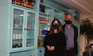Jana Ilic und Lars Vester stehen an dem türkis lackierten Apothekenschrank, der das Herzstück der Einrichtung bildet. - Britta Bohnenkamp-Schmidt