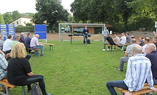 Klaus Poppensieker (l.) und Patrick Schirrmacher vom Vorstand des Fußballclubs Löhne-Gohfeld stellen die Idee zum Umbau des Melbergener Ascheplatzes im Mittelbachstadion vor. Etwa 20 Interessierte sind gekommen - Ulf Hanke