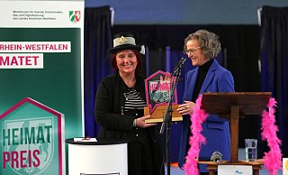 Große Freude bei den "Malunas": Zirkusdirektorin Angela Hölscher (li.) nimmt den Landes-Heimat-Preis NRW von Ministerin Ina Scharrenbach entgegen. - Ilka Gülker