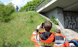 Ein Mitglied der Freiwilligen Feuerwehr fotografiert einen herumstehenden Beobachter zur Beweissicherung. - Andreas Eickhoff