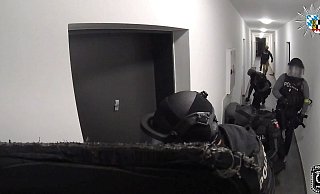 Die slowakische Polizei stürmt ein Appartement - hinter dieser Tür vermuteten sie den Ursprung vieler Schockanrufe. (Handout) - -/Polizei Oberfranken/dpa