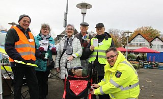 Klaus Steude (v.l.), Jutta Krüger, Volker Rätz und Sieghard Driftmann statten Erika Sander (Mitte) mit Leuchtmaterialien aus. Polizeibeamter Stephan Spanke beklebt den Rollator mit reflektierender Folie. - Heidi Froreich