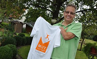 Mut tut gut: Werner Scheips zeigt das T-Shirt mit dem Motto für den Kolpingtag 2015. Der 54-jährige Maschinenbautechniker ist seit Mitte der 90er Jahre Vorsitzender der Kolpingfamilie St. Ursula. - Karin Prignitz