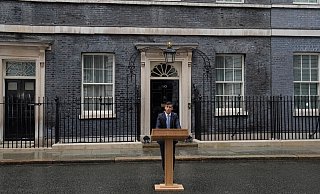 Steht im Regen und kündigt Neuwahlen an: Premierminister Rishi Sunak. - Kin Cheung/AP/dpa