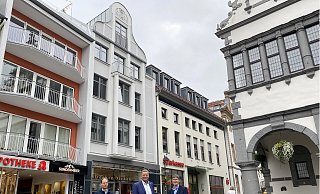 Citymanager Heiko Appelbaum (v.l.), Matthias Goeken, Eigentümer des Gebäudes, und Stadtdenkmalpfleger Thomas Günther vor dem sanierten Bauwerk am Rathausplatz 2. - Stadt Paderborn
