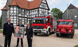Werben fürs Feuerwehrjubiläum: Wehrführer Sebastian Lienen (M.) mit seinen Vorgängern Peter Kesselmeier (l.) und Hubert Westerwalbesloh (r.) vor einem Hilfeleistungslöschfahrzeug (HLF 20), Baujahr 2020, und einem Löschfahrzeug (LF 8), das von 1968 bis 1989 im Dienst stand, im Hövelhofer Schlossgarten. - Ralph Meyer
