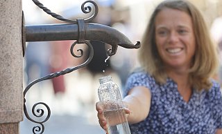 08.08.2022, Sachsen-Anhalt, Wernigerode: Eine Frau bedient sich am Trinkwasserspender im Stadtzentrum. In vielen Städten wird das kostenlose Wasser bereitgestellt. Hier können Besucher ihre Wasservorräte auffüllen oder sich einfach nur etwas erfrischen. In Sachsen-Anhalts Städten gibt es nur wenige öffentliche Trinkwasserbrunnen. Foto: Matthias Bein/dpa +++ dpa-Bildfunk +++ - Matthias Bein