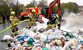 Feuerwehrleute ziehen den Müll auseinander, damit er sich besser löschen lässt. - Ralph Meyer