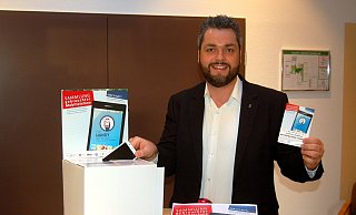 Jugendpfarrer Benjamin Tinz wirbt vor einer der Sammelboxen für die Aktion der Kirche an Heiligabend. - Michael Grundmeier