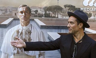 Jude Law vor einem Plakat mit sich als Papst Pius XIII. in der Serie «The Young Pope». (Archivbild) - picture alliance / dpa