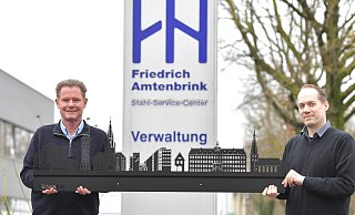 Die Verantwortlichen des Stahl-Service-Centers Friedrich Amtenbrink um den Geschäftsführenden Gesellschafter Stefan Döring (links) und Mitarbeiter Olaf Goldbecker präsentieren die Gütersloher Skyline. - sport/presse/foto Dünhölter