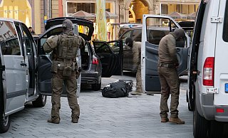 Auf dem Marktplatz rüsten sich die Spezialkräfte der Bielefelder Polizei, die mit elf Fahrzeugen angerückt waren, für den Einsatz im Gebäude der Volksbank. - Ralph Meyer