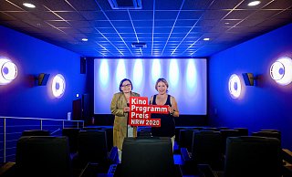 Kinobetreiberinnen Judith und Ute Schlinker mit dem Logo des 30. Kinoprogrammpreis im Kinosaal des Cineplex in Warburg. - Hojabr Riahi / Film- und Medienstiftung NRW