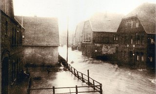 Das Wasser der Beke überflutete die damalige Kreisstraße in der Ortsmitte. - Chronik Heimatpflege