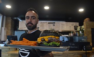 Faulus Celik mit dem außergewöhnlichen schwarzen Burger. - Alexander Lange