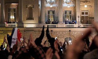 Fans applaudieren den Spielern der französischen Nationalmannschaft auf dem Balkon des Hotels Crillon in Paris. - Francois Mori/AP/dpa