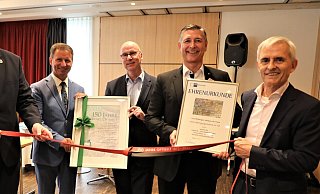 Bürgermeister Daniel Hartmann (v. l.), Landrat Michael Stickeln, Konrad Ummen, IHK-Chef Jürgen Behlke und Reinhold Mühlbeyer mit Urkunden und Gummiband, dem Deuser-Band von Arntz Optibelt. - Simone Flörke