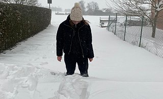 NW-Mitarbeiterin Anthea Moschner versinkt vor der Haustür bis zum Knie im Schnee. - Moschner