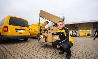 Hochgestapelt: Ansgar Peine zieht aus der erweiterten Pakethalle ein Rollgitter mit Paketen zum Lieferwagen.  - David Schellenberg
