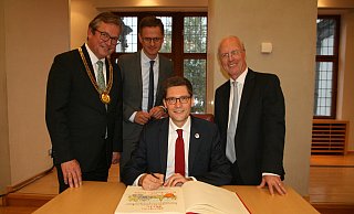 Zur Freude von Bürgermeister Michael Dreier (v. l.), dem CDU-Bundestagsabgeordneten Carsten Linnemann und dem Vorsitzenden des Bürgervereins, Rudolf Wansleben, trägt sich Christian Hirte ins Goldene Buch der Stadt ein. - Andreas Götte