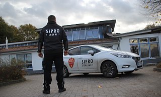 Ein Mitarbeiter eines Sicherheitsdienstes bewacht das Gebäude der Kita Krempoli in Bünde. Die Kindertagesstätte ist durch ein Feuer zerstört worden. - Florian Weyand