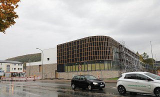 Das Gerüst an der Fassade des neuen Hallenbades steht bereits, das Holz lässt noch auf sich warten. Derweil finden entlang der Lütmarser Straße Arbeiten statt für die Hausanschlüsse. - Simone Flörke