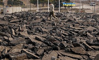 Ein Bauarbeiter geht über eine kaputte Straße vor dem Grenzübergang zwischen dem ukrainisch kontrollierten Gebiet und dem von prorussischen Separatisten kontrollierten Gebiet in Luhansk. - Foto: Vadim Ghirda/AP/dpa