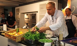 Koch und Restaurantinhaber Marc Höhne erklärt seinen zehn Kochkursteilnehmern, welche Kräuter am besten zum Gericht passen. - Alexandra Golfinger