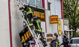 Feuerwehrleute entfernen unter Polizeischutz ein Schild am Vereinsheim der Rockergruppe «Bandidos». - Foto: Dieter Menne/dpa