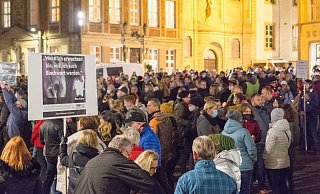 Einige Teilnehmer haben Kerzen oder Plakate dabei. Polizei und Ordnungsamt kontrollieren, ob Abstände und die Maskenpflicht eingehalten wird. - Lena Henning