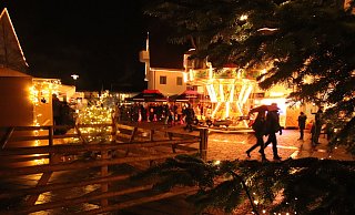 Etwas schleppend läuft am Freitag Weihnachtsmarkt Schloß Holte an. Der Nieselregen hat sicherlich so manchen davon abgehalten, sich sofort auf dem Holter Kirchplatz umzusehen. Gut besucht ist von Anfang an der Stand des SCW Liemke (hinten). - Sabine Kubendorff