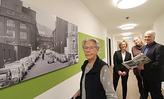 Bewohnerin Elfriede Zöller schaut sich das Bild des Dürkopp-Geländes an. Christine Bode (v.l.), Einrichtungsleiterin Stephanie Krumsiek und Jochen Rath blättern im Bielefeld-Buch. - Sylvia Tetmeyer