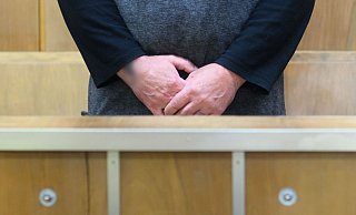 Der Angeklagte Zarko D. steht im Gerichtssaal in der Anklagebank. Er soll im Juli 2021 im Stadtpark Eilenriede einen auf einer Parkbank sitzenden Obdachlosen getötet haben. - Julian Stratenschulte/dpa