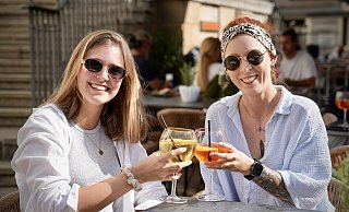 Farina Albrecht (l.) und Sarah Müller haben sich spontan für einen Aperitif auf dem Alten Markt entschieden. Hier gibt es auch noch Bielefelder Erdbeeren zu kaufen. - Peter Unger