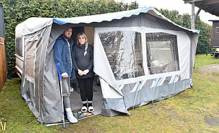 Keine Bleibe für den Winter. Dustin und Jacqueline Schröder stehen im Eingang zum Vorzelt, dass sie an den 5,5 Meter langen Wohnwagen angebaut haben. Dort leben sie momentan mit ihren drei Kindern. - Gunter Held