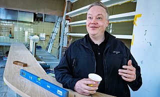 Hendrik Wortmann steht mit einem Kaffeebecher in der Hand hinter der neuen Theke im ehemaligen Milestones. Der Umbau ist noch im vollen Schwung. - Barbara Franke
