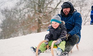Manchen macht der Schnee gute Laune. So wie hier dem vierjährigen Matz und seinem Papa Marco. Sie rodeln den in der Nachbarschaft des Tengegebiets beliebten „Rodelberg“ hinab. - Besim Mazhiqi